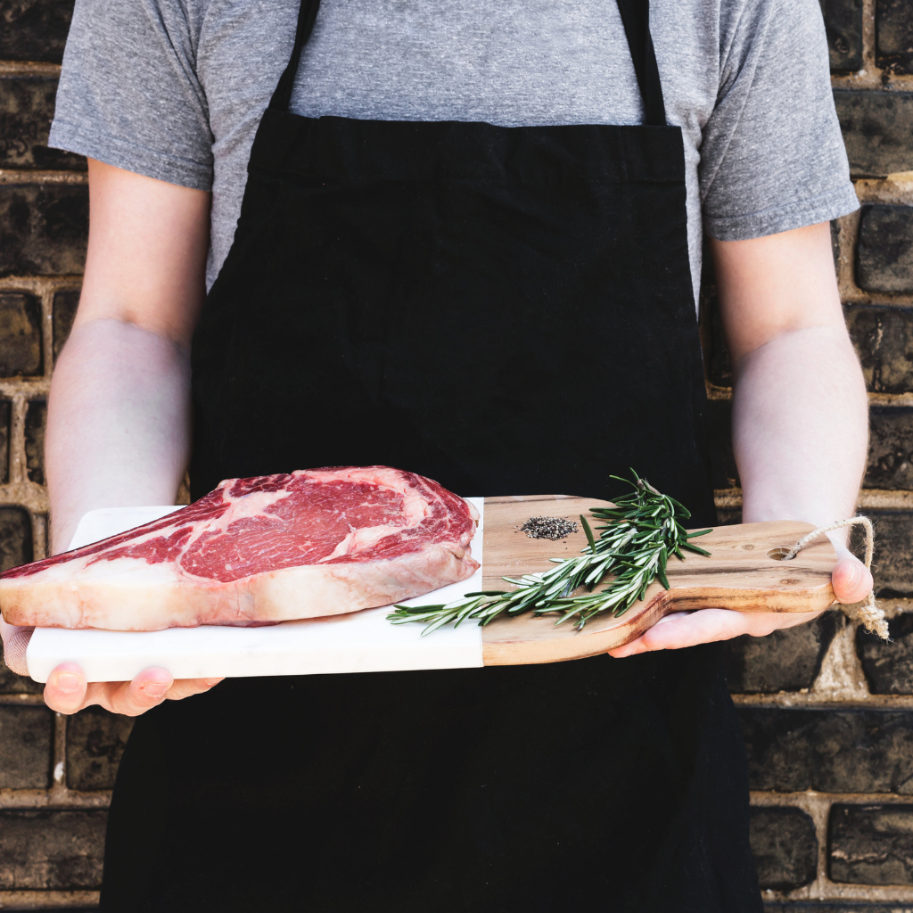 chef presenting fresh meat on a chopping board