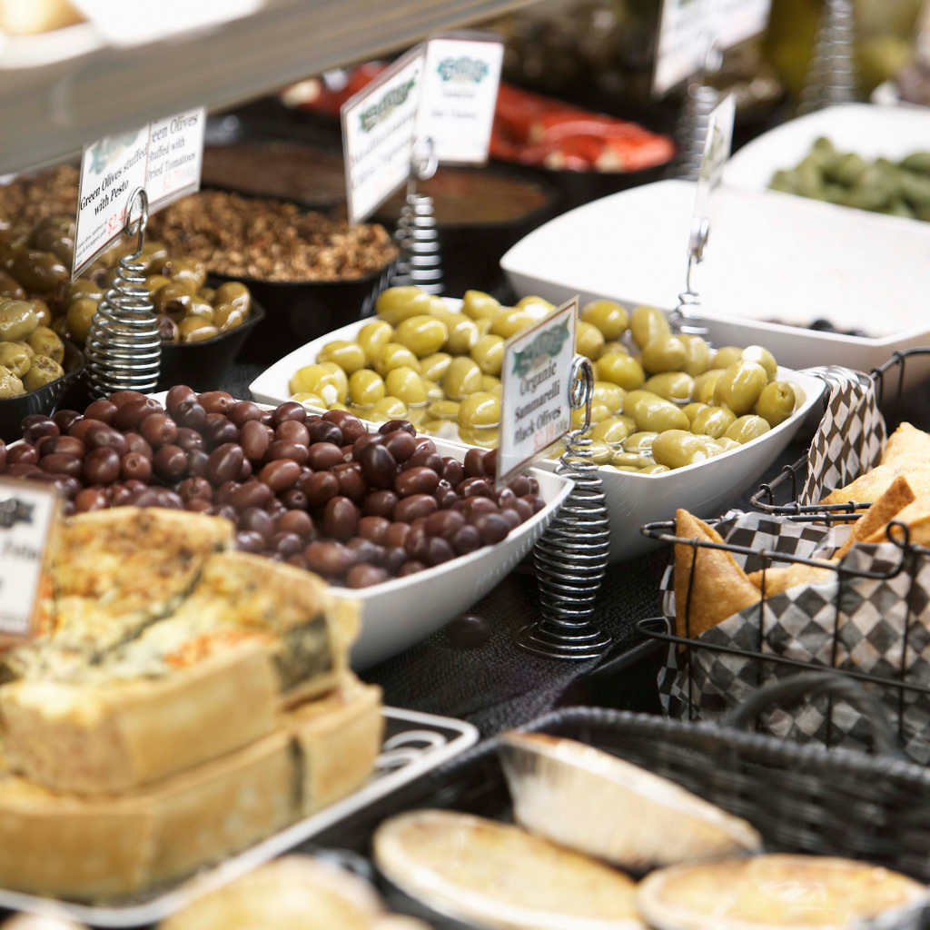 deli items with quiche and olives and pies