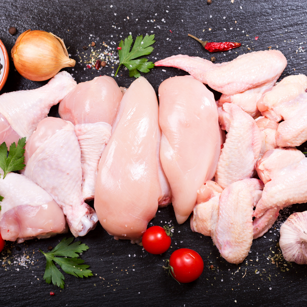 various cuts of fresh chicken on granite plate